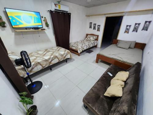 a room with three beds and a flat screen tv at Pequeño apartamento in Dolega