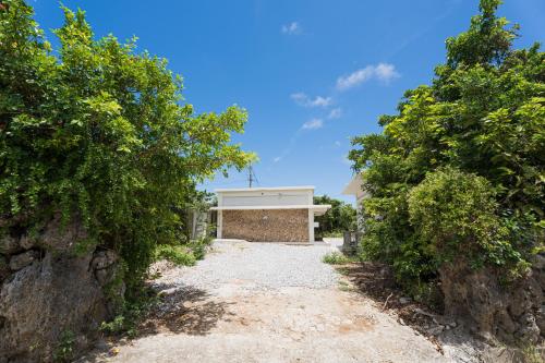 a driveway to a house with a garage at ダイバーズヴィラYoNNER in Aguni