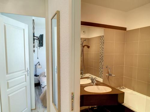 une salle de bain avec un lavabo et un miroir dans l'établissement Les Menuires : 3 pièces rénové 40m² avec parking couvert et équipement complet, au pied des pistes - FR-1-178-380, aux Menuires