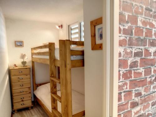 - une chambre avec 2 lits superposés et un mur en briques dans l'établissement Les Menuires : 3 pièces rénové 40m² avec parking couvert et équipement complet, au pied des pistes - FR-1-178-380, aux Menuires