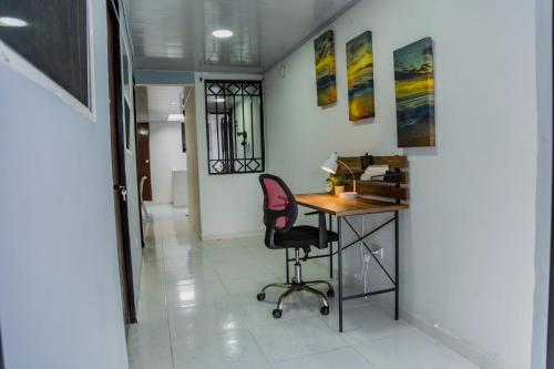 an office with a desk and a chair in a hallway at Coliving7 Aparta Hotel & Habitaciones in Ibagué