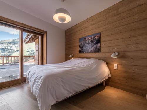 une chambre avec un lit et une grande fenêtre dans l'établissement Bel appartement moderne à Méribel Mottaret avec terrasse - 6 pers - FR-1-613-118, à Les Allues