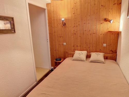 une chambre avec un lit avec deux oreillers dessus dans l'établissement Charmant 2 pièces, balcon sud, 5 pers, pied des pistes et commerces - Les Menuires, Rés. Carlines I - FR-1-178-391, aux Menuires