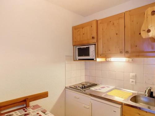 une petite cuisine avec un évier et un micro-ondes dans l'établissement Charmant 2 pièces, balcon sud, 5 pers, pied des pistes et commerces - Les Menuires, Rés. Carlines I - FR-1-178-391, aux Menuires