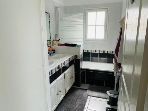 une salle de bain blanche avec un lavabo et une fenêtre dans l'établissement Villa calme avec piscine privée, animaux admis, WiFi - FR-1-323-552, à Saint-Jean-de-Monts