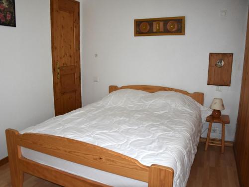 Ce lit se trouve dans une chambre dotée d'un cadre en bois. dans l'établissement Appartement 3P à Pralognan-la-Vanoise - Proche commerces - FR-1-464-232, à Pralognan-la-Vanoise