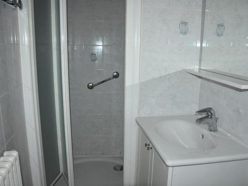 une salle de bain blanche avec un lavabo et une douche dans l'établissement Appartement 3P à Pralognan-la-Vanoise - Proche commerces - FR-1-464-232, à Pralognan-la-Vanoise