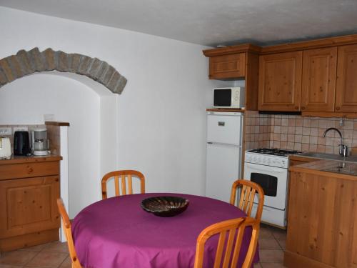 d'une cuisine avec une table recouverte d'un chiffon violet. dans l'établissement Appartement 3P à Pralognan-la-Vanoise - Proche commerces - FR-1-464-232, à Pralognan-la-Vanoise