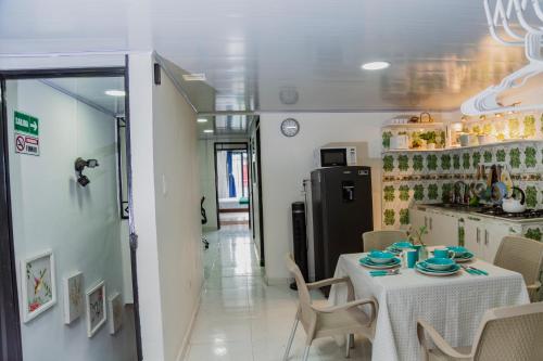 a dining room with a table and a refrigerator at Coliving7 Aparta Hotel & Habitaciones in Ibagué