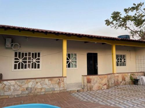 a house with yellow trim and a patio in front of it at Edícula in Porto Velho