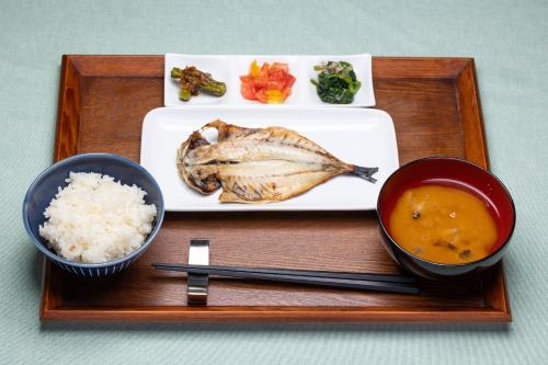 a tray with a plate of food with a fish and rice at カナリアンホテル in Tateshina