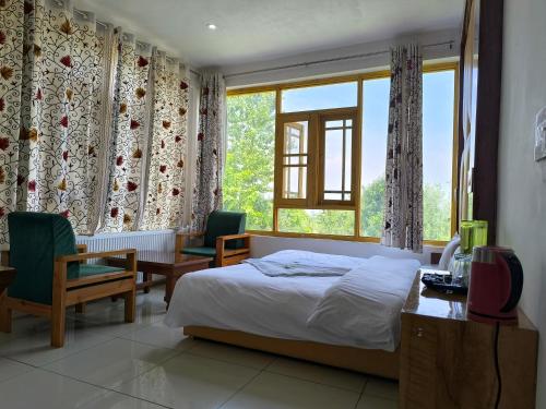 Postel nebo postele na pokoji v ubytování Gulmarg GS Residency Hotel