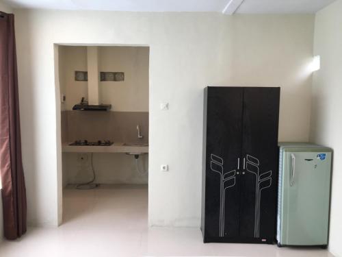 a kitchen with a black refrigerator in a room at Z Stay Kost Gresik in Giri