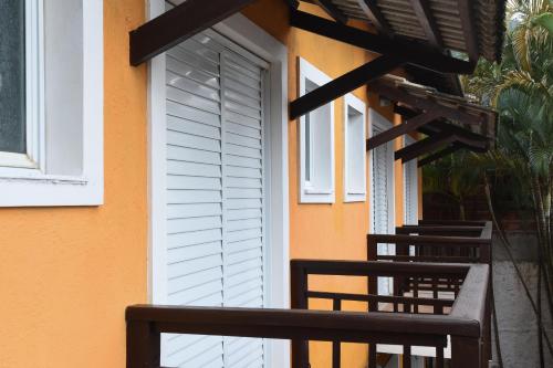 a balcony of a house with a wooden railing at Pousada Rosa dos Ventos Juquehy in Juquei
