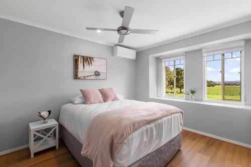 a white bedroom with a bed and a ceiling fan at Kilmoyla Farm Stay in Leopold