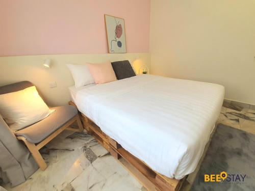 a bedroom with a large bed and a chair at Jenjarom No 32 Modern Cozy Homestay for 4 Pax by Beestay in Jenjarum