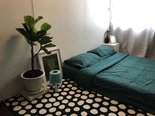 a bedroom with a green bed and a potted plant at Hong hostel in Bangkok