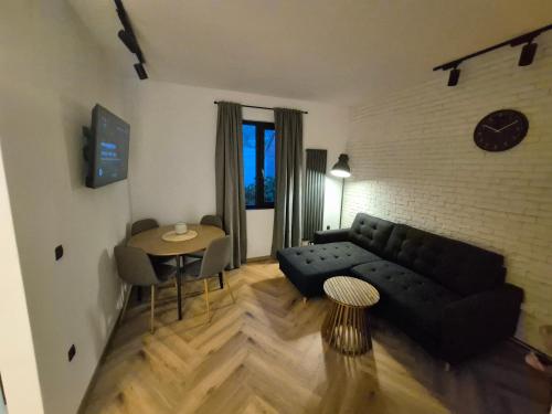 a living room with a black couch and a table at Design Loft in Reşiţa