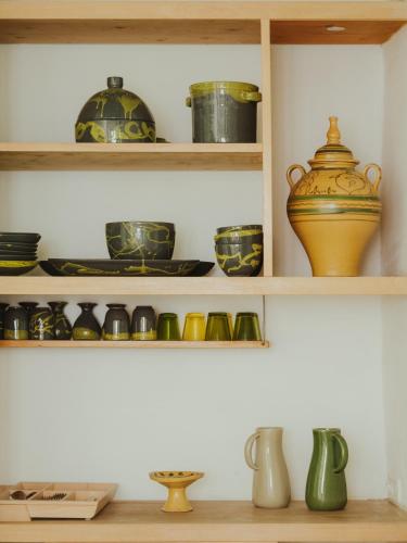 a shelf filled with different types of bowls and vases at La Chambre bleue in Tunis
