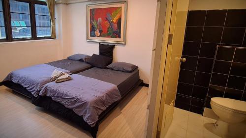 a small bedroom with a bed and a toilet at DonMueang station hotel in Ban Don Muang