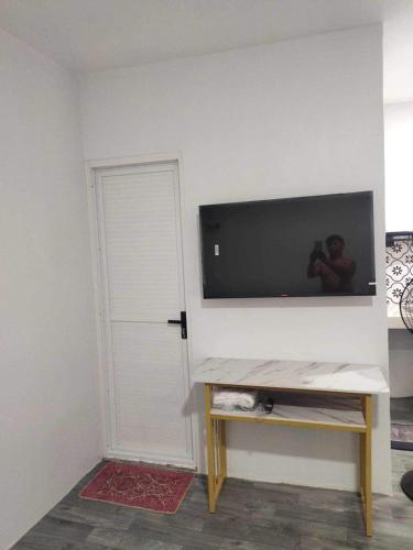 a room with a tv on a wall with a door at Pike Guest House 2 in Dagupan