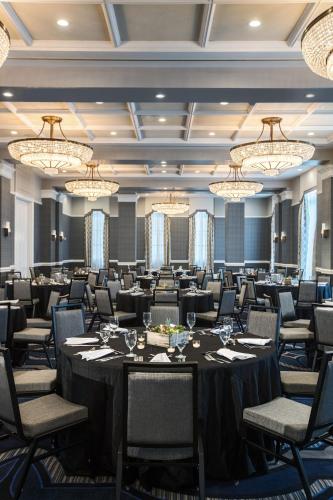 a conference room with tables and chairs and chandeliers at The Notary Hotel, Philadelphia, Autograph Collection by Marriott in Philadelphia