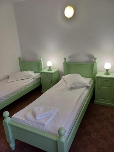 two green beds in a room with two lamps on them at Hotel Hefaistos - Sovata in Sovata