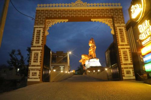 an archway with a statue of a woman in front of a building at Shiv Ashray Resort in Nāthdwāra