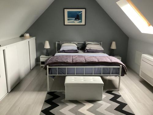 une chambre avec un lit dans un grenier dans l'établissement Le Passage, à Vineuil