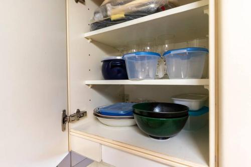 a cupboard with bowls and other kitchen utensils at Warabe in Otaru