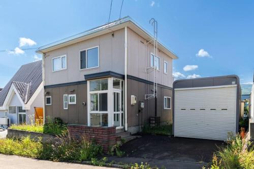 a large house with a white garage at Warabe in Otaru