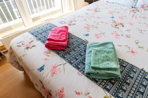 a bed with two towels sitting on top of it at Warabe in Otaru