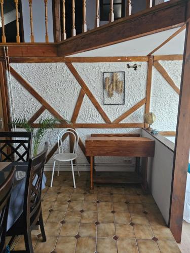 a table and chairs in a room with a staircase at La bergerie in La Bruyère