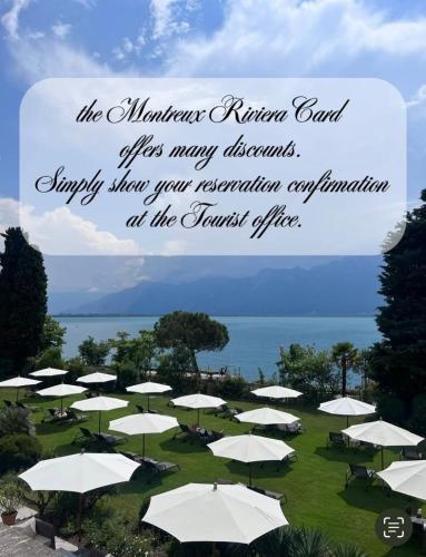 a group of white umbrellas in a field with the ocean at Montreux Luxury Suite in Montreux