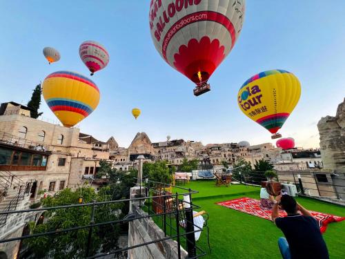 a group of hot air balloons flying over a city at Century Cave Hotel in Goreme