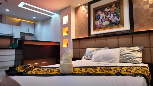 a bedroom with a bed and a painting on the wall at Kay Hotel and Residences in Angeles