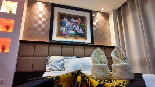 a bedroom with a bed with a picture on the wall at Kay Hotel and Residences in Angeles