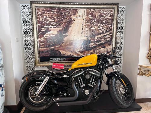 a yellow motorcycle parked in front of a painting at Siam Champs Elyseesi Unique Hotel in Bangkok