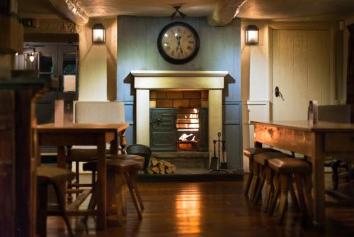 The Fenwick Steak & Seafood Pub في لانكستر: غرفة بها موقد مع ساعة على الحائط