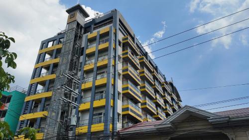 a tall building with yellow and gray at Kay Hotel and Residences in Angeles
