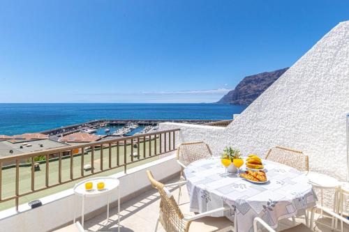 a table on a balcony with a view of the ocean at Panoramic View Tamara Apt By Dream Homes Tenerife in Acantilado de los Gigantes