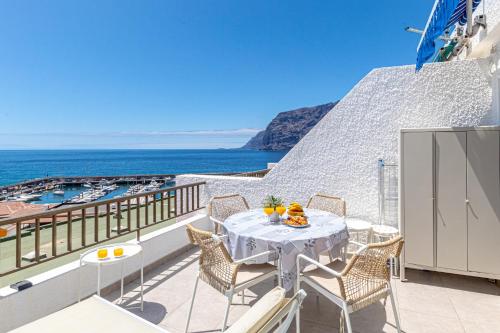 a balcony with a table and chairs and the ocean at Panoramic View Tamara Apt By Dream Homes Tenerife in Acantilado de los Gigantes