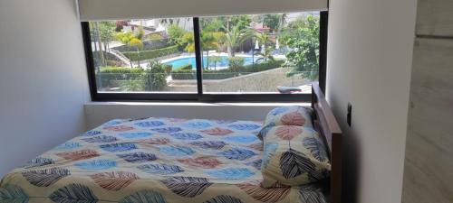 a bed in a room with a window at Hermoso Depto en Condominio Astoria in Acapulco