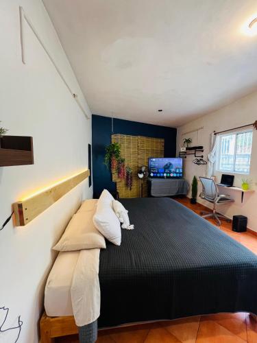 a bedroom with a black bed with white pillows at Escape Romántico en Tepoztlán, Habitación Privada y Céntrica in Tepoztlán