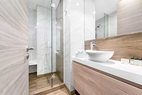 bagno con lavandino e doccia in vetro di FIRST CLASS Studio Rustic Charm in SOL BAY a Dubai