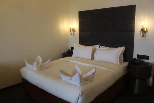 a bedroom with a large bed with two white pillows at Gulf Hotel Mumbai- The Boutique Hotel Colaba Mumbai in Mumbai
