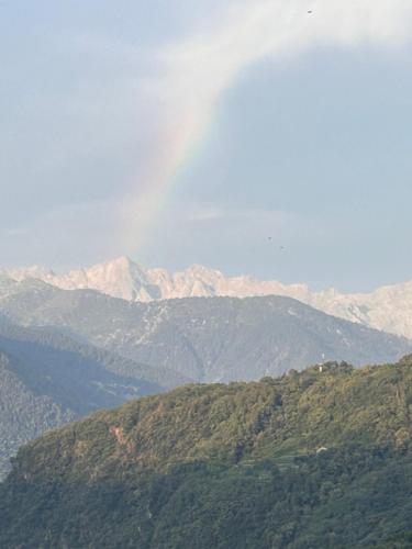 a view of a mountain range with a rainbow in the sky at Valtellinda in Bianzone