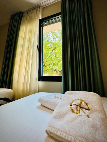 a bedroom with two beds and a window with a bow at Gogo's Boutique Hotel in Dhërmi