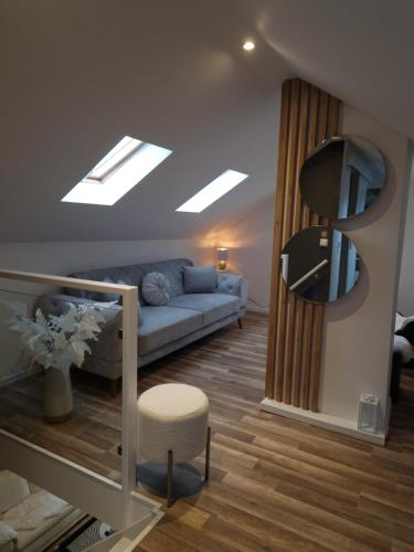 a living room with a blue couch and a mirror at soul & spa holiday home in Arendal