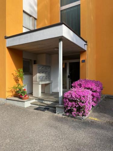 a building with purple flowers in front of it at Ful e Fra un oasi di pace in Ticino in Minusio